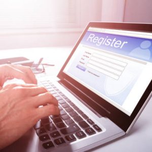 Businessman's Hand Filling Online Registration Form On Laptop